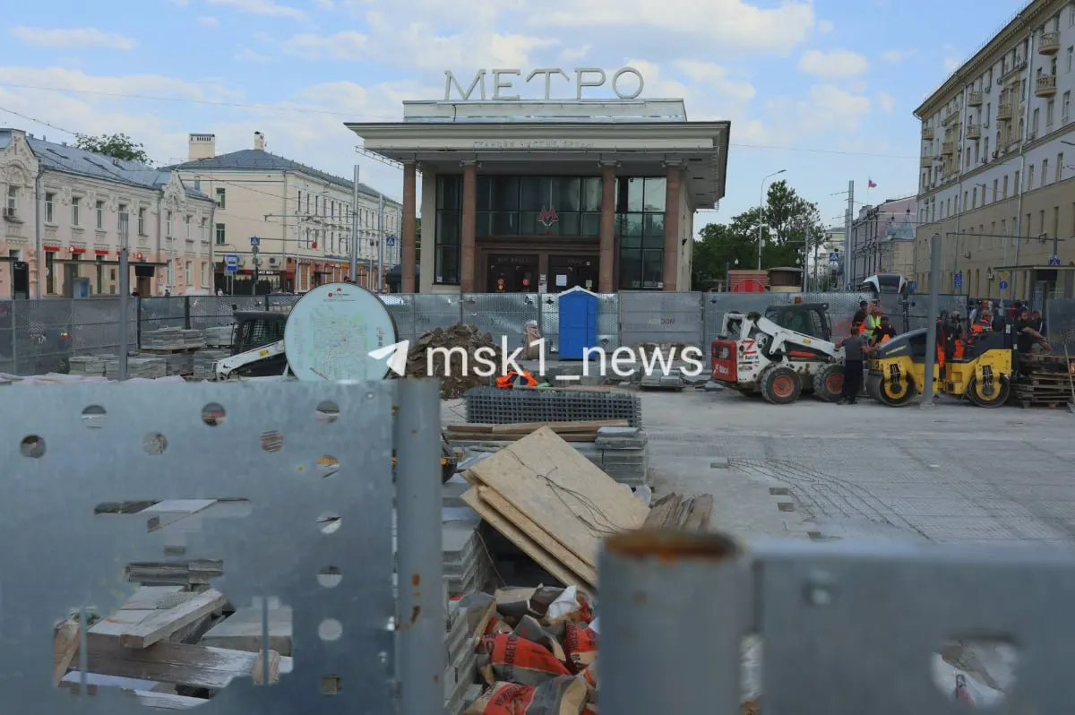 Возле станции метро установили строительные заборы: рабочие меняют бордюры и плитку, а скамейки загружают в самосвалы. Сроки и причины работ пока неизвестны.