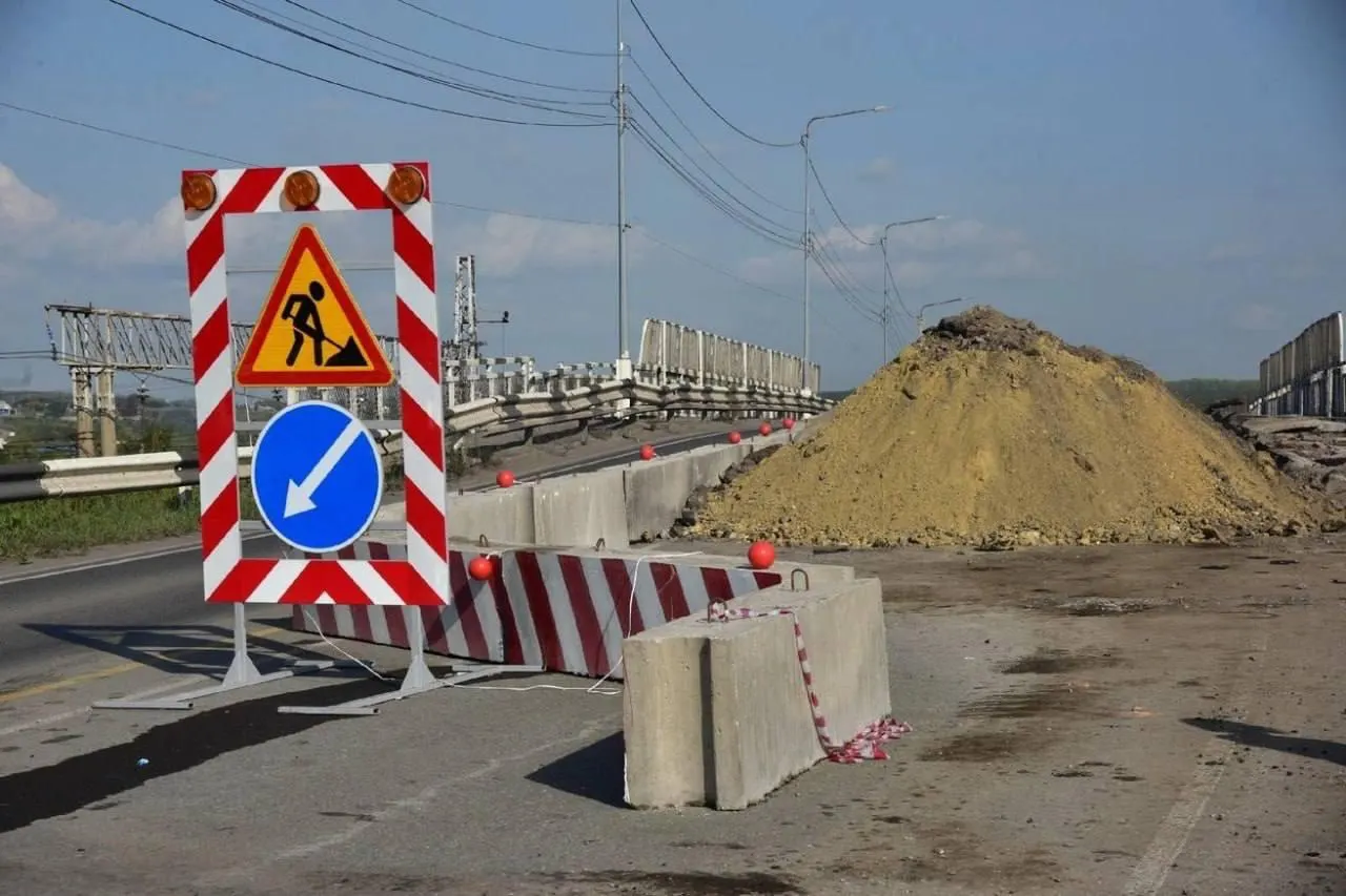 Путепровод закрыт уже 3,5 года: ожидавшееся открытие в марте отложили, работы возможны лишь в «окна» между поездными маршрутами, из‑за чего жители вынуждены ездить по переполненной объездной дороге.