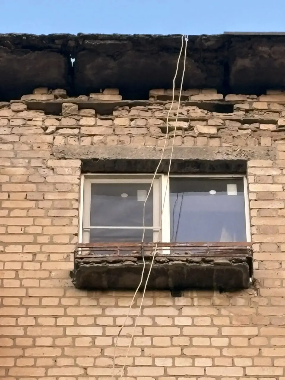 В доме №4 на улице Даугавской ухудшаются несущие конструкции и разрушается кровля — из кирпичной кладки выветривается цемент. За аварийной стеной находится квартира человека с инвалидностью по зрению, который оказался один на один с угрозой для жилья.