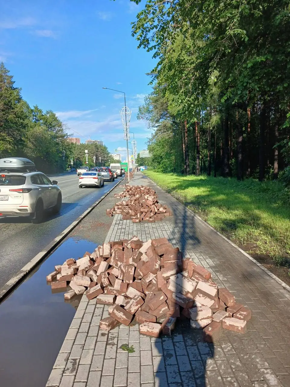 На улице Худякова обновляют тротуарную плитку и красную полосу для велосипедистов в участке вдоль бора, где пешеходов мало, а осветительные столбы стоят прямо на велодорожке.