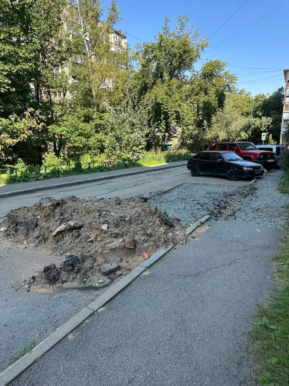 У входа в здание остаётся перекопанный тротуар. Жители жалуются, а чиновники заявляют об устранении работ и прикладывают снимок с другой улицы.