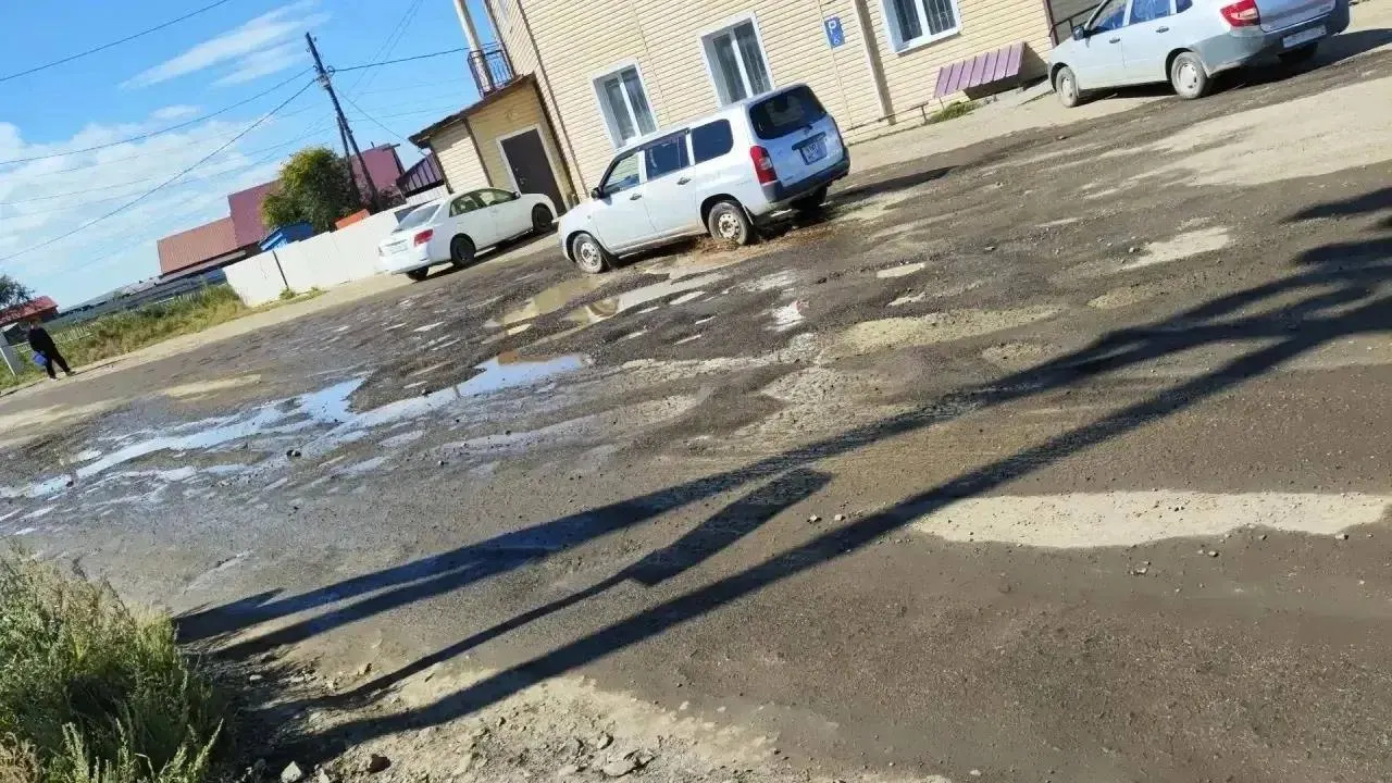 Жители жалуются на ямы на дорогах, обширную траву вдоль обочин и запустение площади после ремонта, а также зафиксированные ДТП возле больницы; власти обещают завершить работы и покос до наступления зимы.