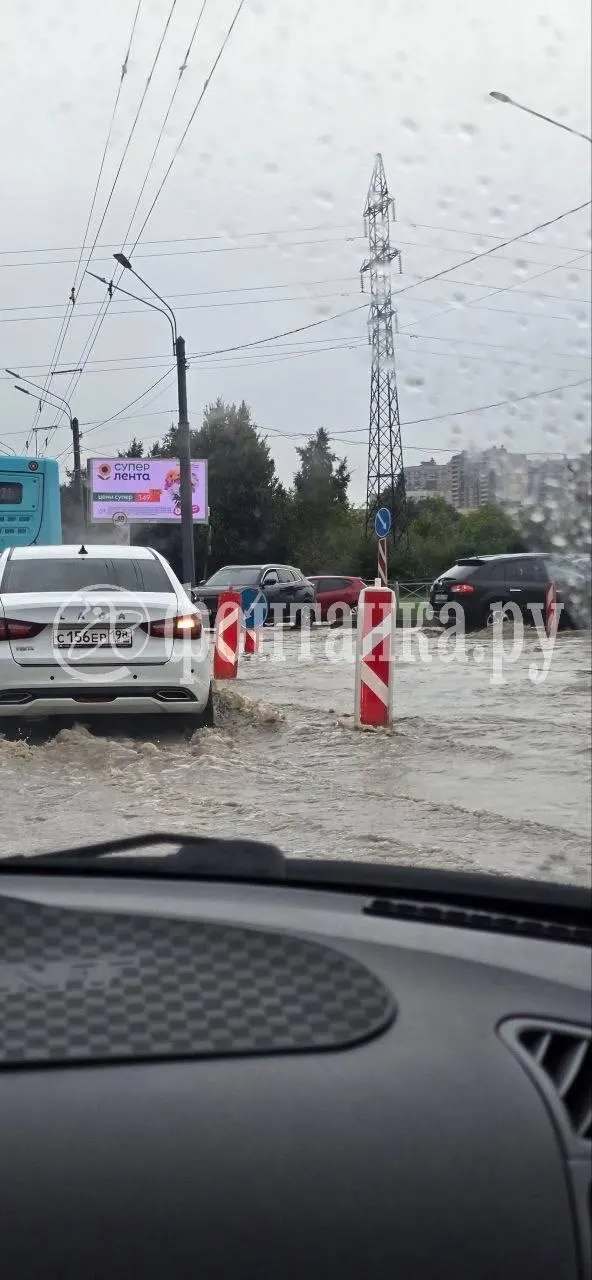 Утечка холодной воды привела к образованию лужи на проезжей части; специалисты работают над локализацией протечки и отводом воды.