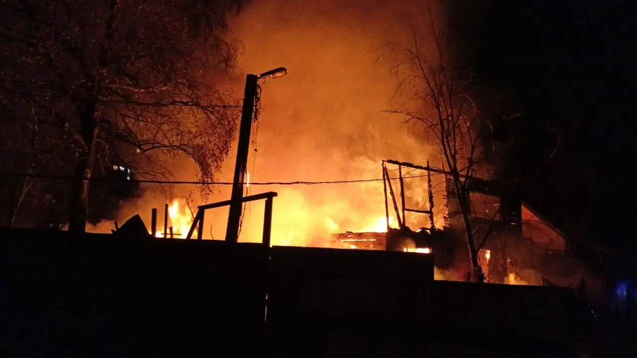 Черный столб дыма поднялся над Мытищами; пожарные борются с огнем в жилом доме частного сектора.